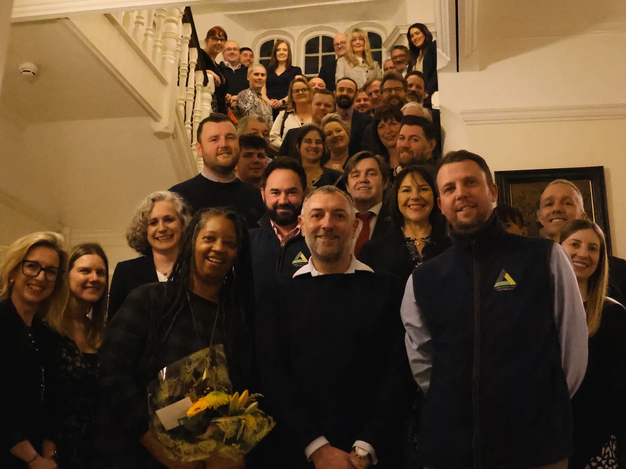 Team of people on a staircase celebrating