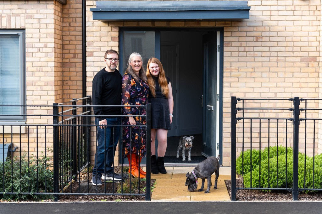 Family outside a new home with Cala at Wintringham, St Neots.