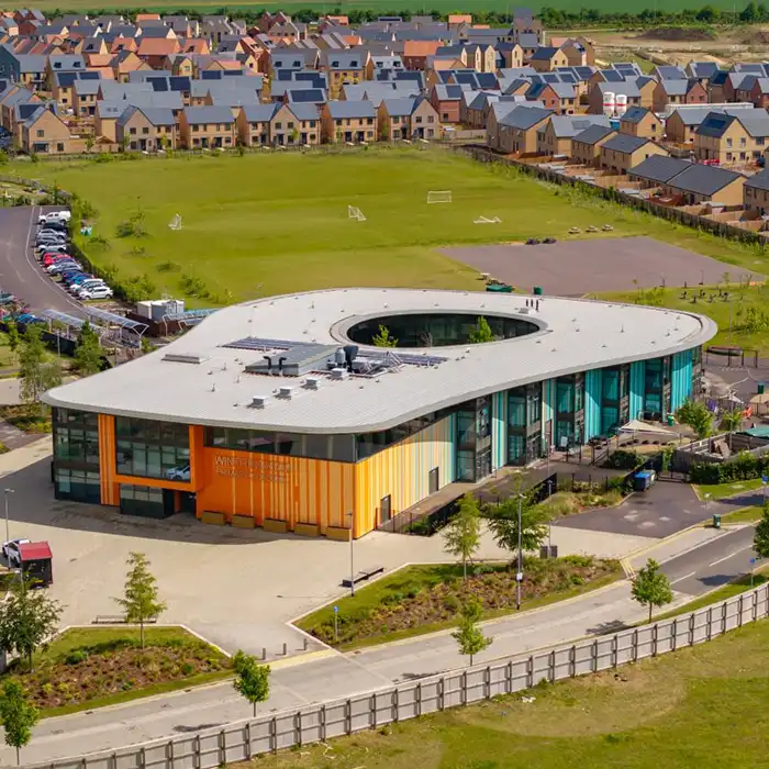 Aerial view of Wintringham Primary Academy with playing fields and new-build homes beyond