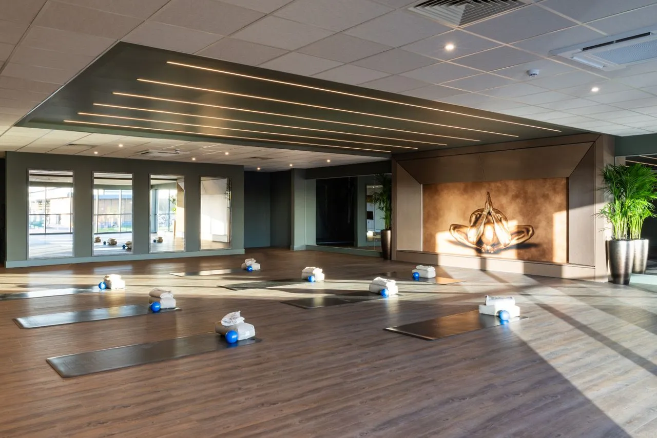 Spacious Mind & Body yoga studio at David Lloyd St Neots set up with yoga mats, blocks, and towels for a class.